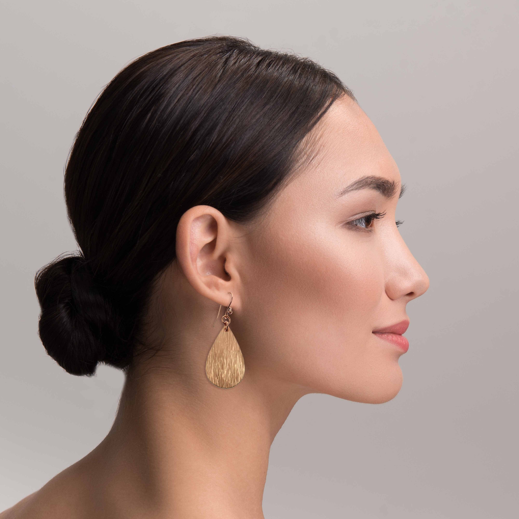 Elegant Woman Wearing Bark Embossed Small Teardrop Earrings