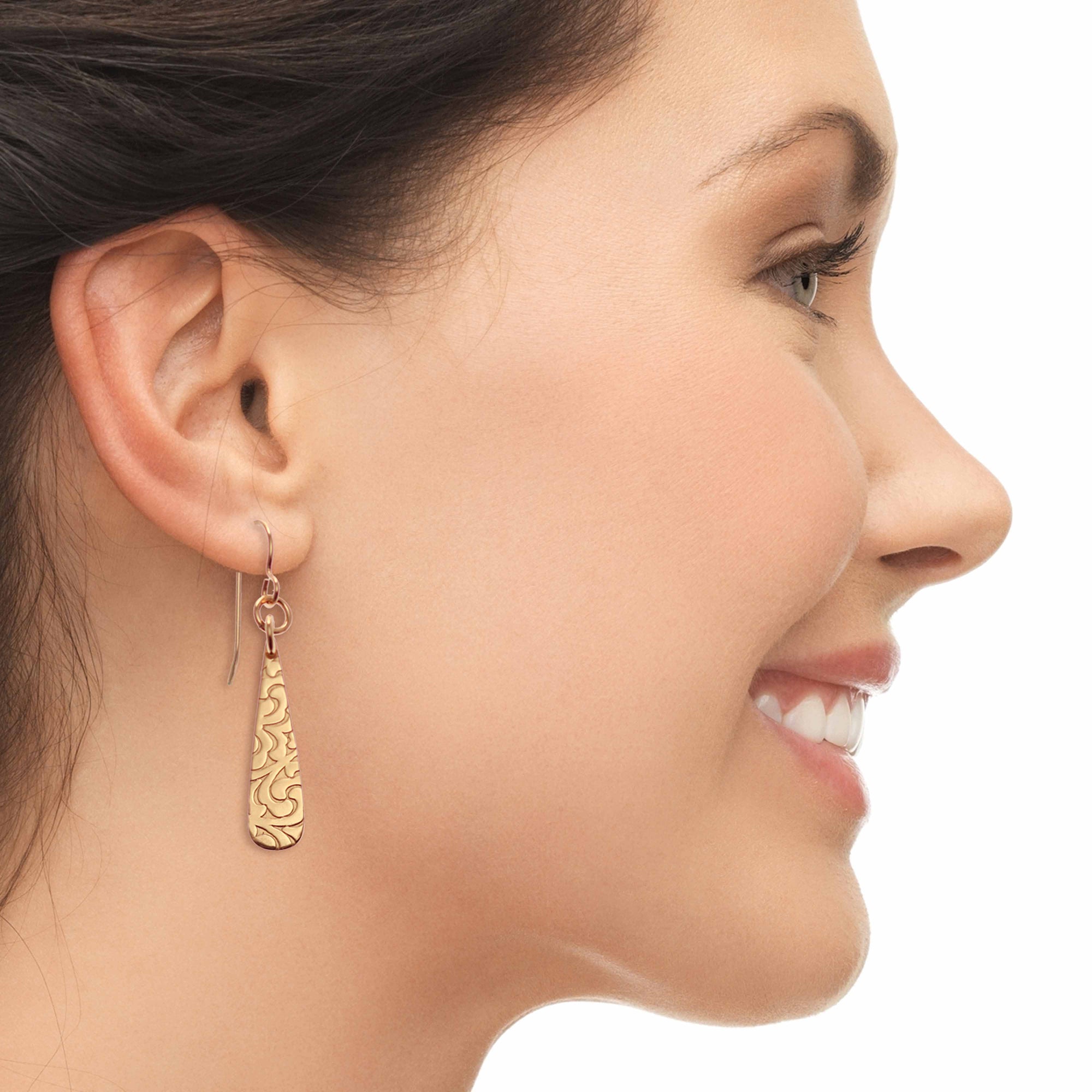 Smiling Woman Wearing Damask Embossed Mini Bronze Teardrop Earrings