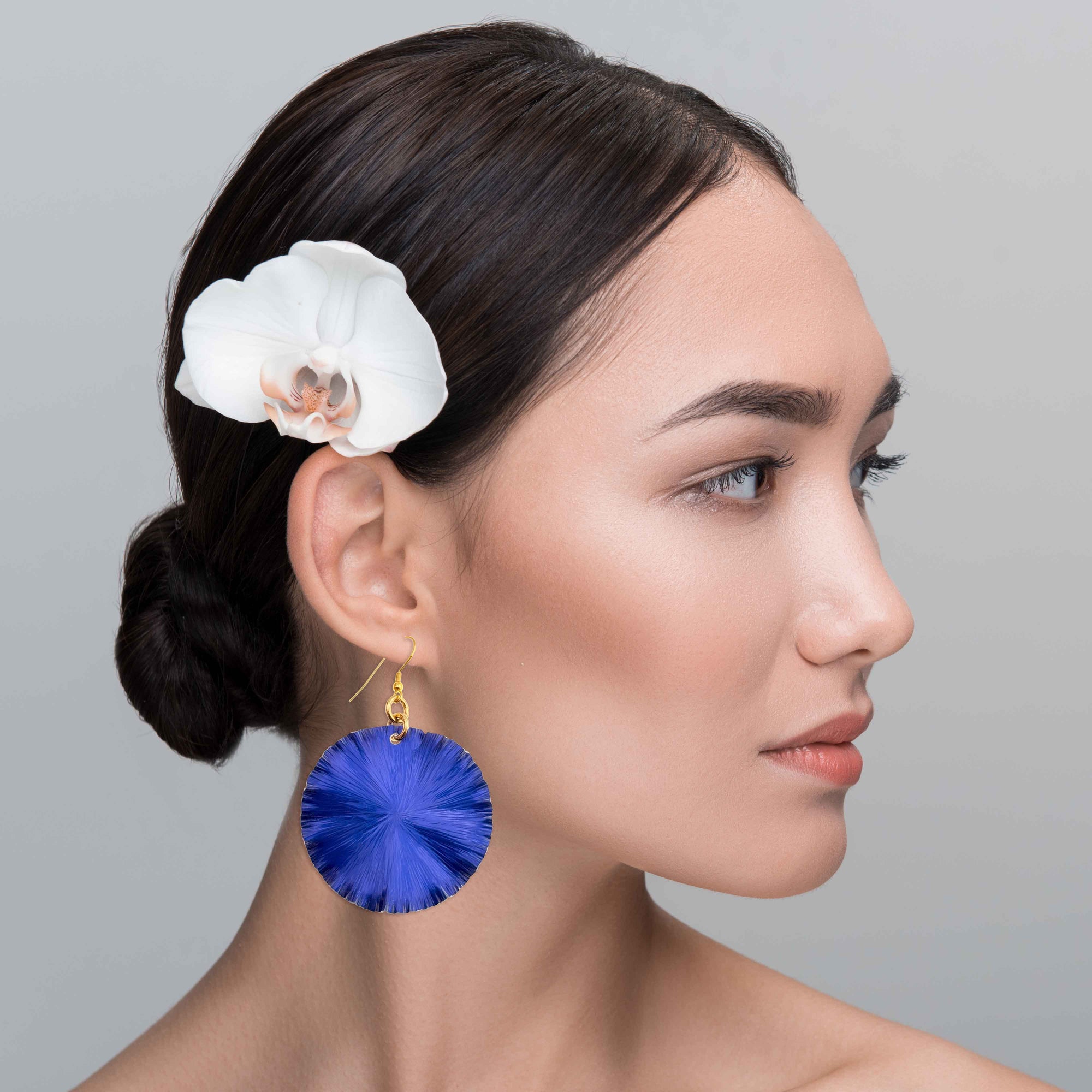 A Chic Woman Wearing Large Cobalt Blue Lily Pad Anodized Aluminum Leaf Earrings