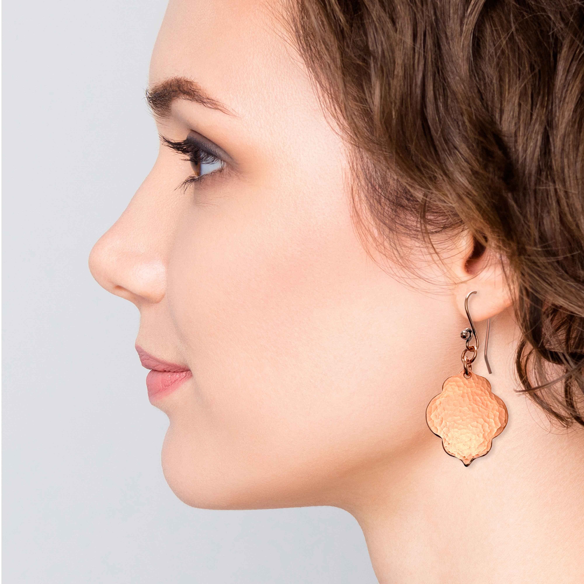 A Chic Woman Wearing Small Hammered Copper Quatrefoil Dangle Earrings