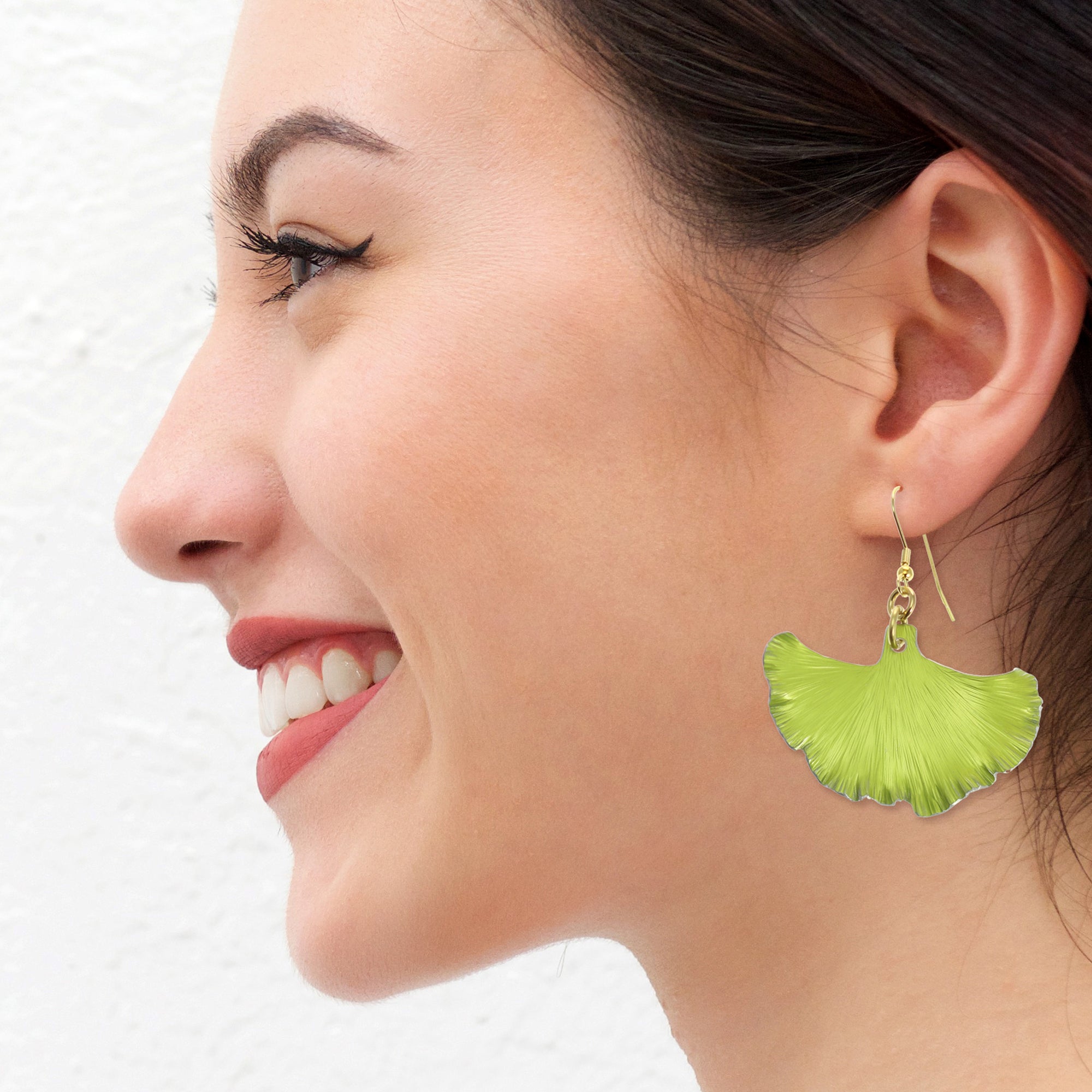 A Chic Woman Wearing Medium Sour Candy Apple Anodized Aluminum Ginkgo Leaf Earrings