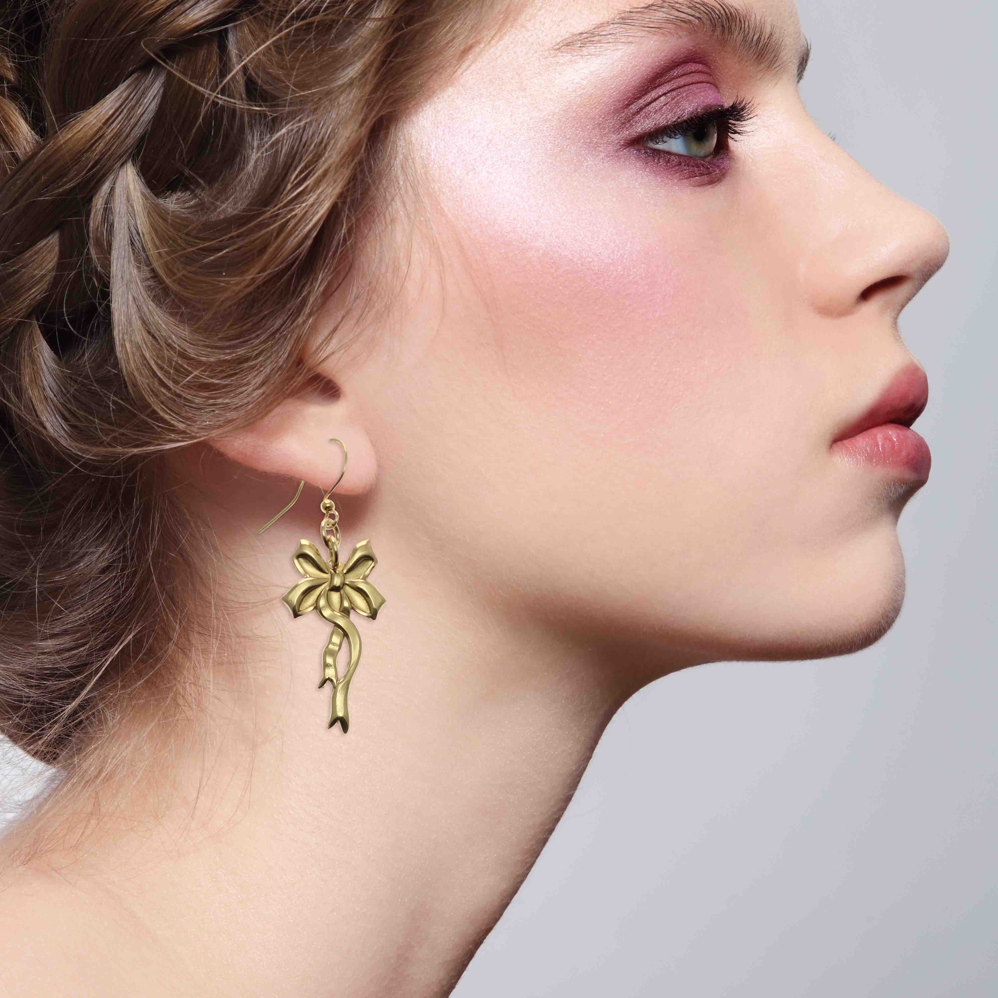 Stunning Woman Wearing Yuletide Ribbon Nu Gold Brass Dangle Earrings